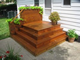 Wooden stairwells leading to a white room, with plants in flowerpots adding a touch of greenery to the exterior